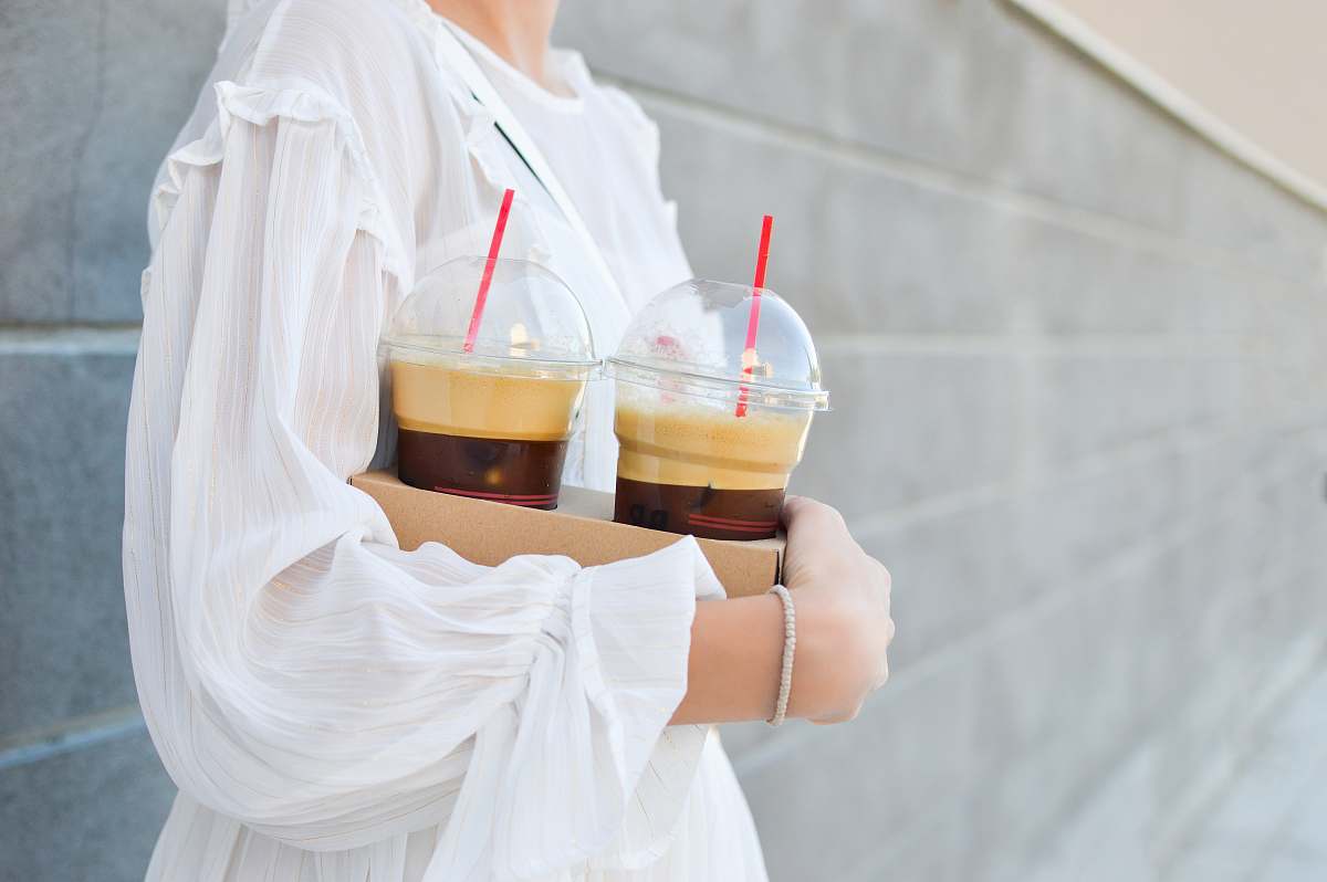 iced coffee woman carrying disposable cups coffee